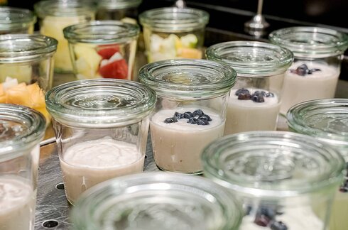 Jogurt in Gläsern auf einem Frühstücksbuffet.