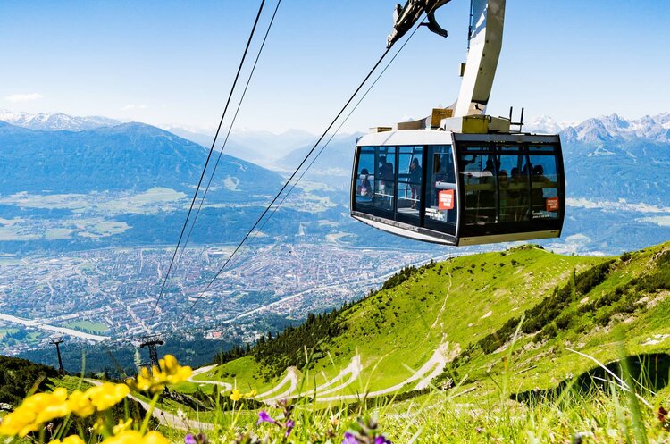 Gondel der Nordkettenbahn mit grüner Almwiese.