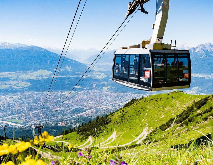 Gondel der Nordkettenbahn mit grüner Almwiese.