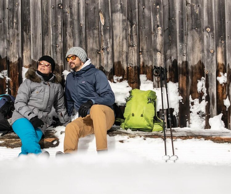 Wanderer im Winter bei Rast auf Bank
