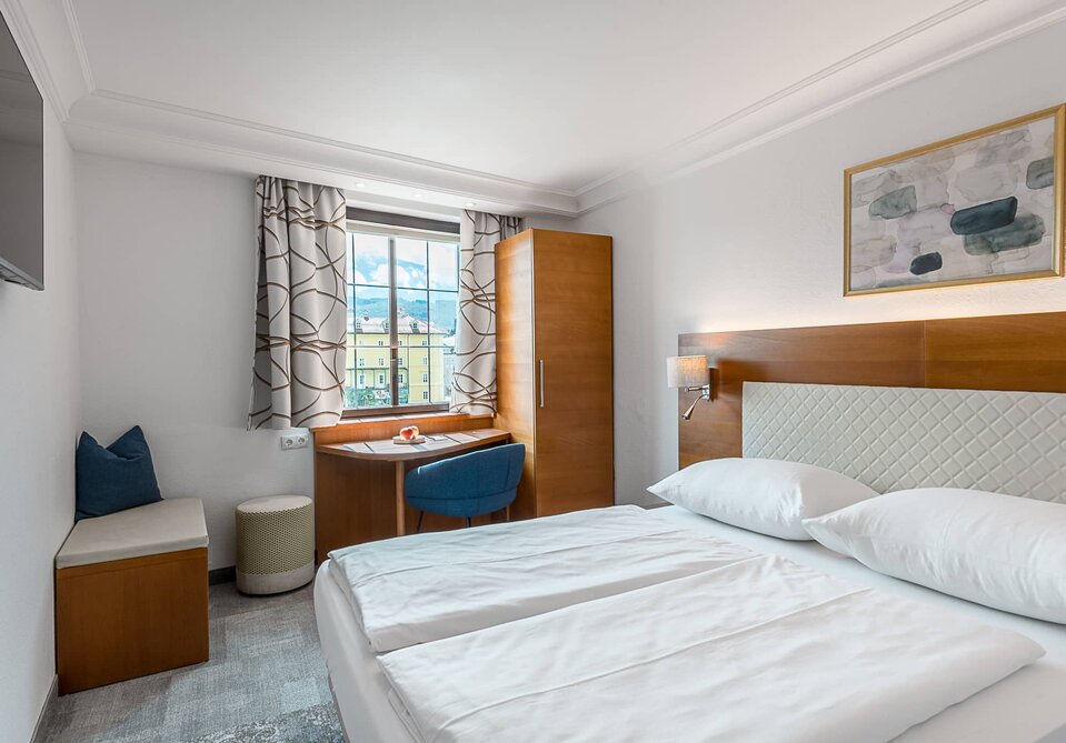 Hotelzimmer mit Doppelbett und Fernseher