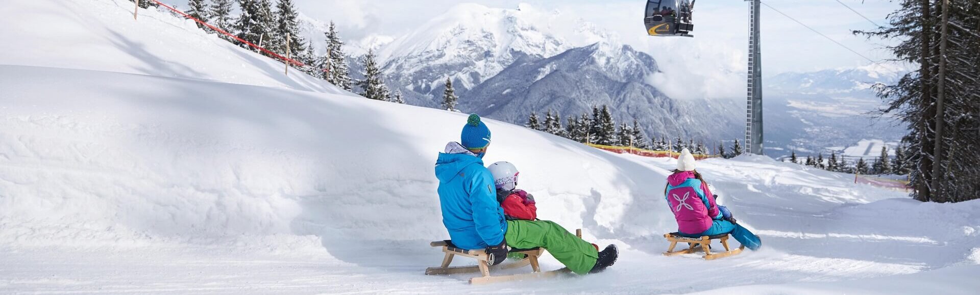 Eine Familie rodelt in Oberperfuss.