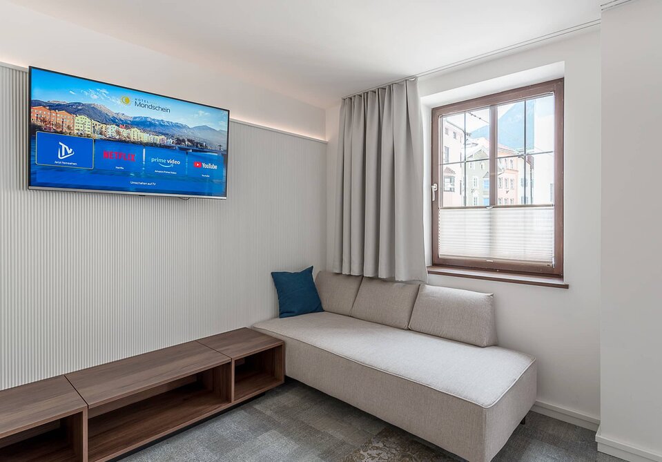 Ein Sofabett und ein Fernseher in einem Zimmer.