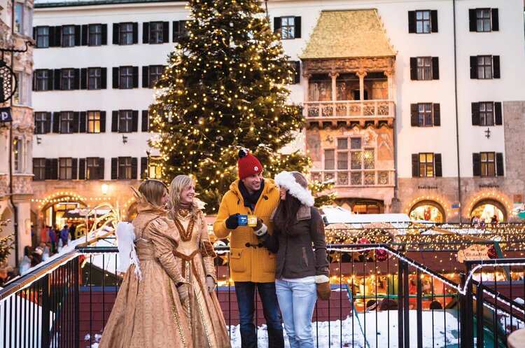 Personen in Winterkleidung auf einem Weihnachtsmarkt