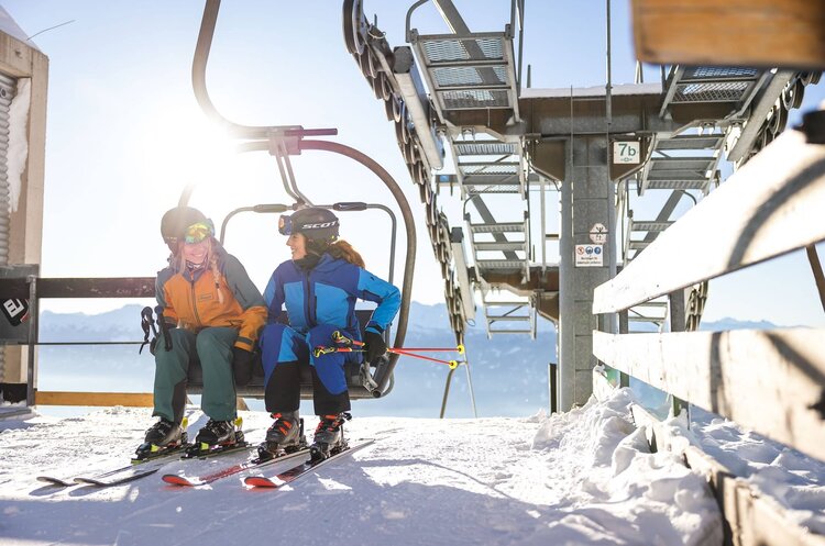 Zwei Skifahrerinnen am Sessellift auf der Seegrube