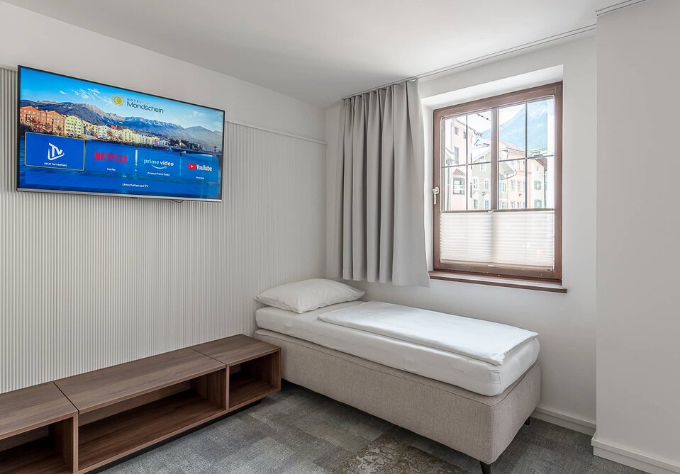 Ein Sofabett und ein Fernseher in einem Zimmer.